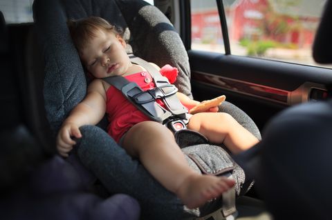 Ein Kind schläft im Auto.