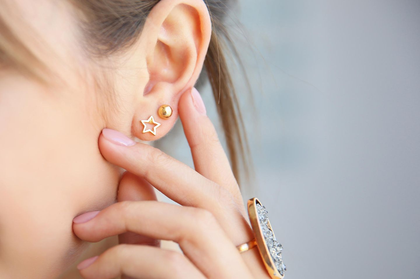 Ohrenschmalz entfernen: Frau berührt ihr Ohr