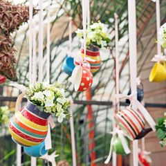 Gartendeko selber machen: Bunte Tassen und Kannen mit Pflanzen gefüllt hängen von der Decke