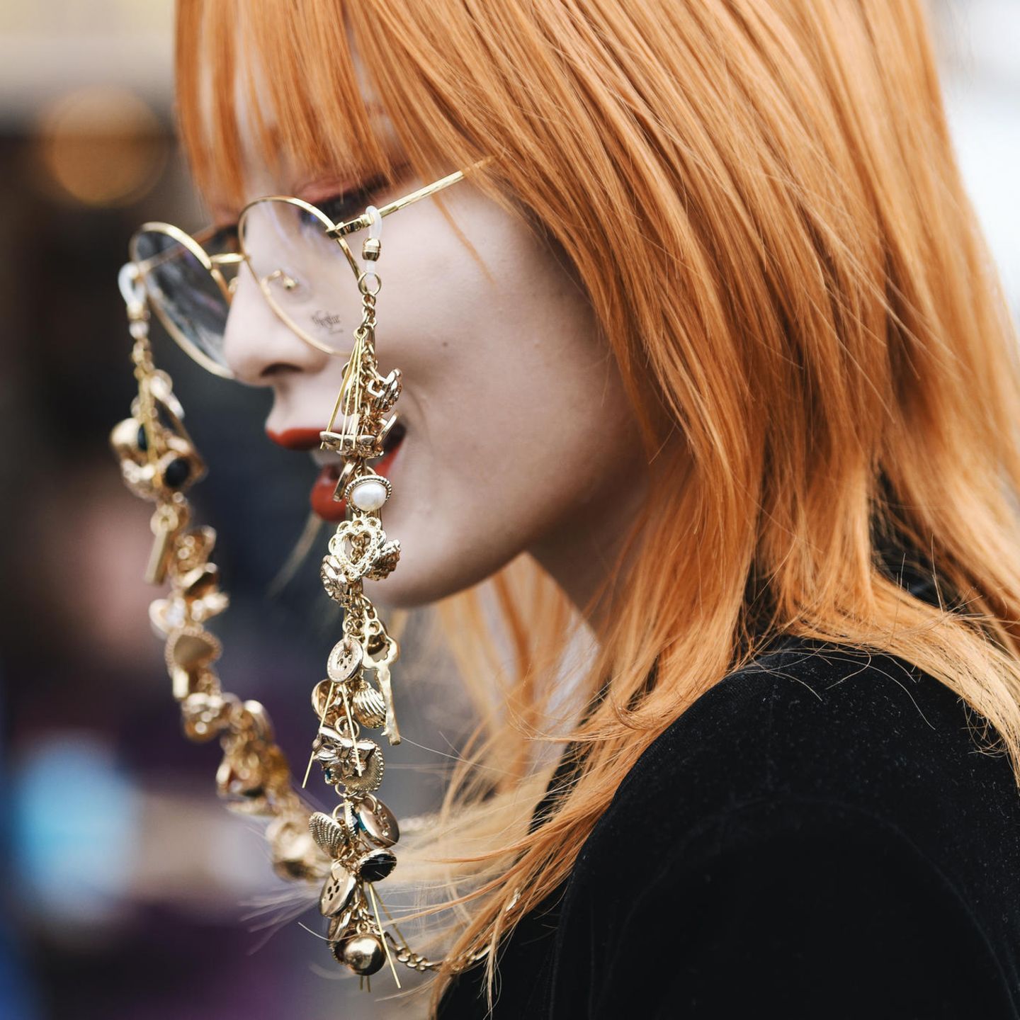 Kupfer Haare: Frau mit orange-kupferfarbenem Haar und runder Brille mit auffälliger Brillenkette