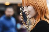 Kupfer Haare: Frau mit orange-kupferfarbenem Haar und runder Brille mit auffälliger Brillenkette