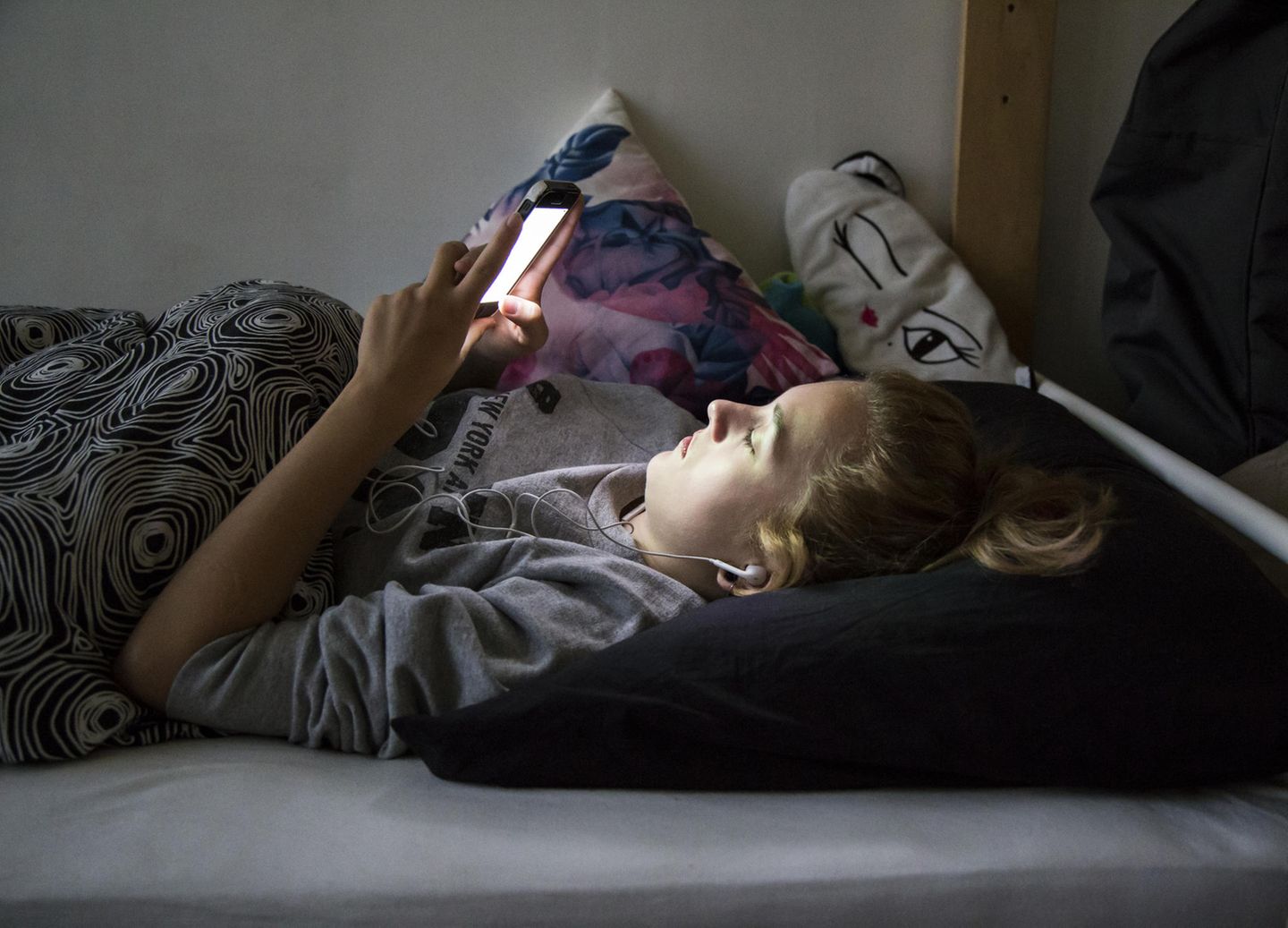 Stubenhocker: Teenager mit Handy auf dem Bett