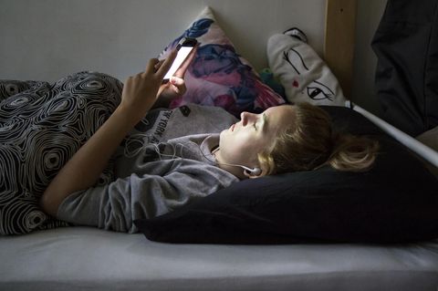 Stubenhocker: Teenager mit Handy auf dem Bett
