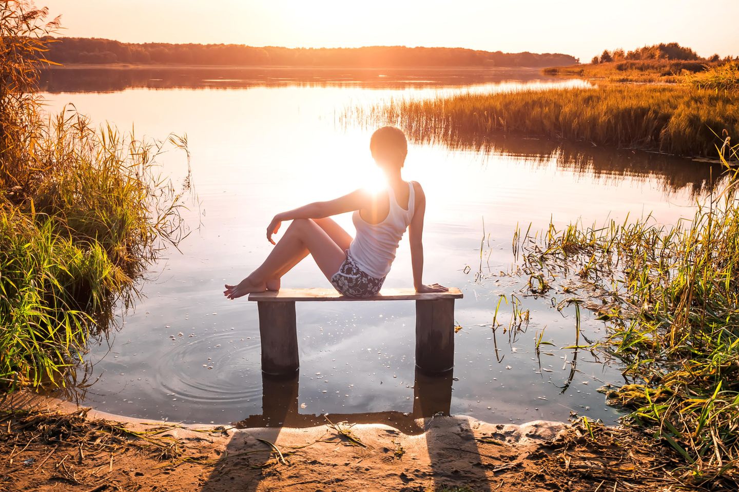 Horoskop: Eine einsame Frau sitzt vor einem See