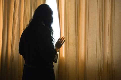 Psychische Erkrankungen: Frau am Vorhang
