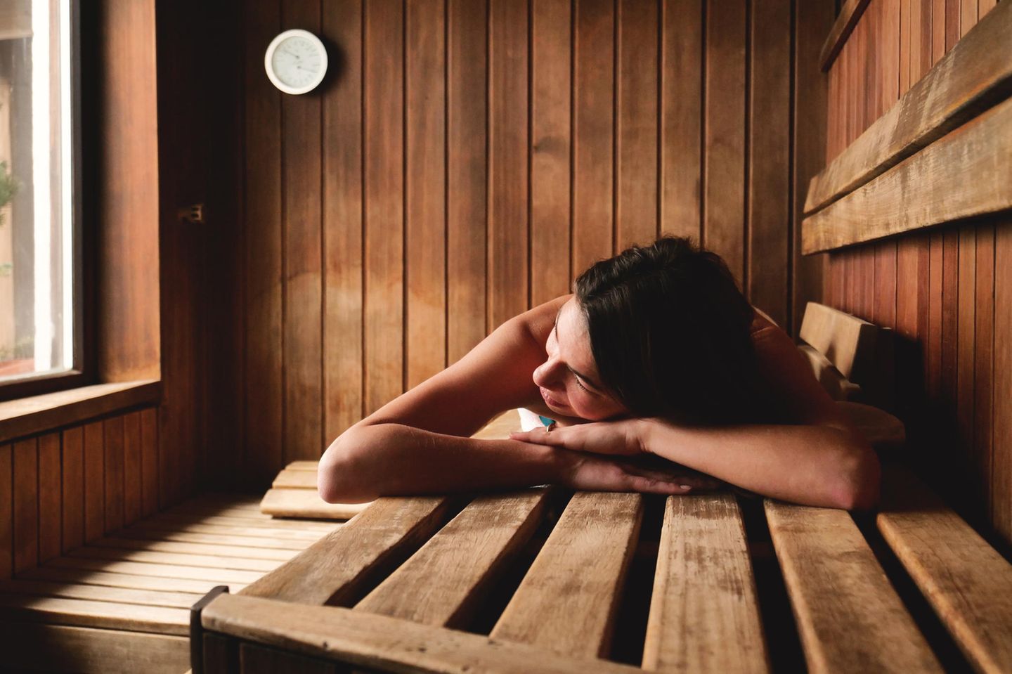 Nackt in der Sauna: Frau sauniert im Liegen