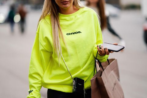 Neon im Alltag stylen: Frau im neonfarbenen Pullover