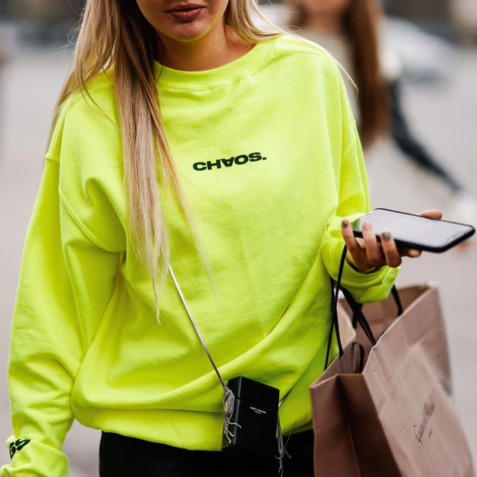 Neon im Alltag stylen: Frau im neonfarbenen Pullover