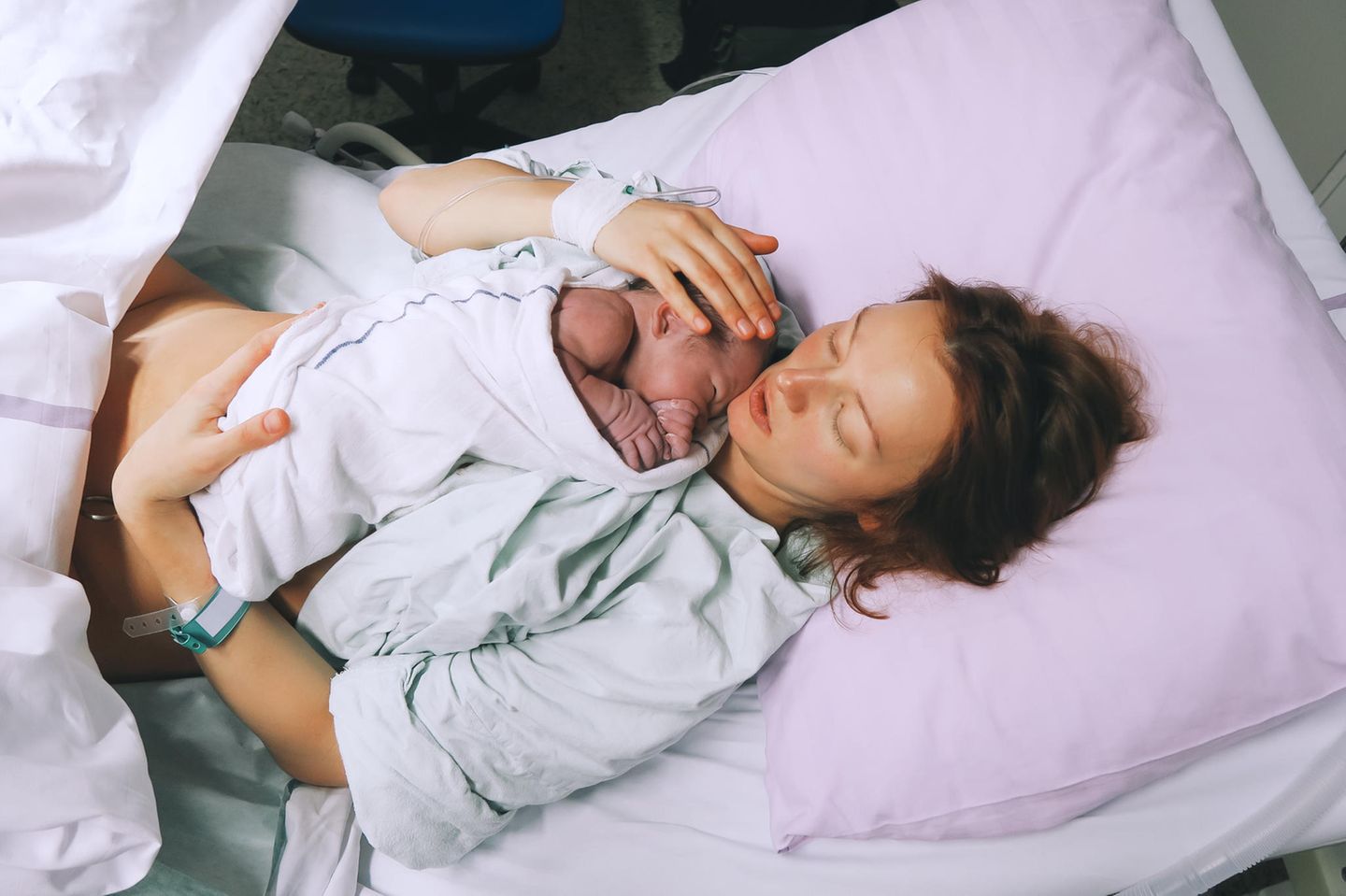 Dammriss: Mutter mit neugeborenem Baby im Kreissaal