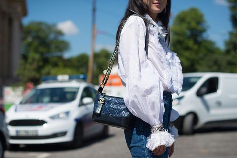 Weiße Bluse stylen: Frau mit weißer Bluse und Chaneltasche