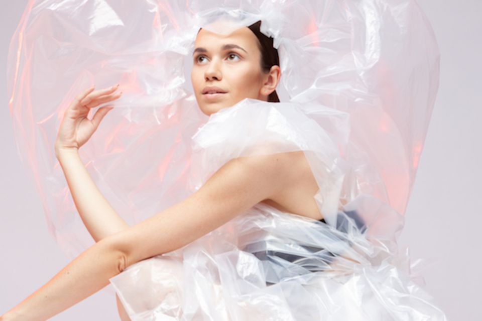 Mode aus recyceltem Plastik: Frau in Plastikumhang