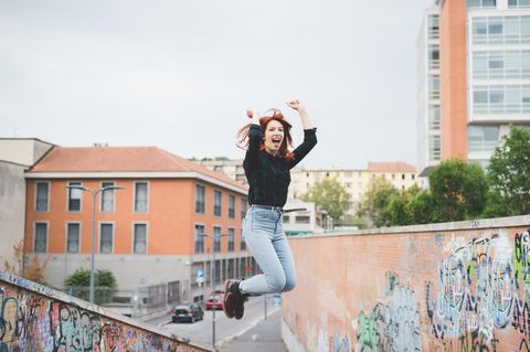 Selbstwertgefühl stärken: Eine junge Frau springt in die Luft