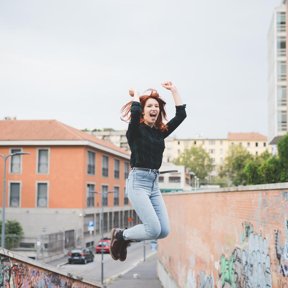 Selbstwertgefühl stärken: Eine junge Frau springt in die Luft