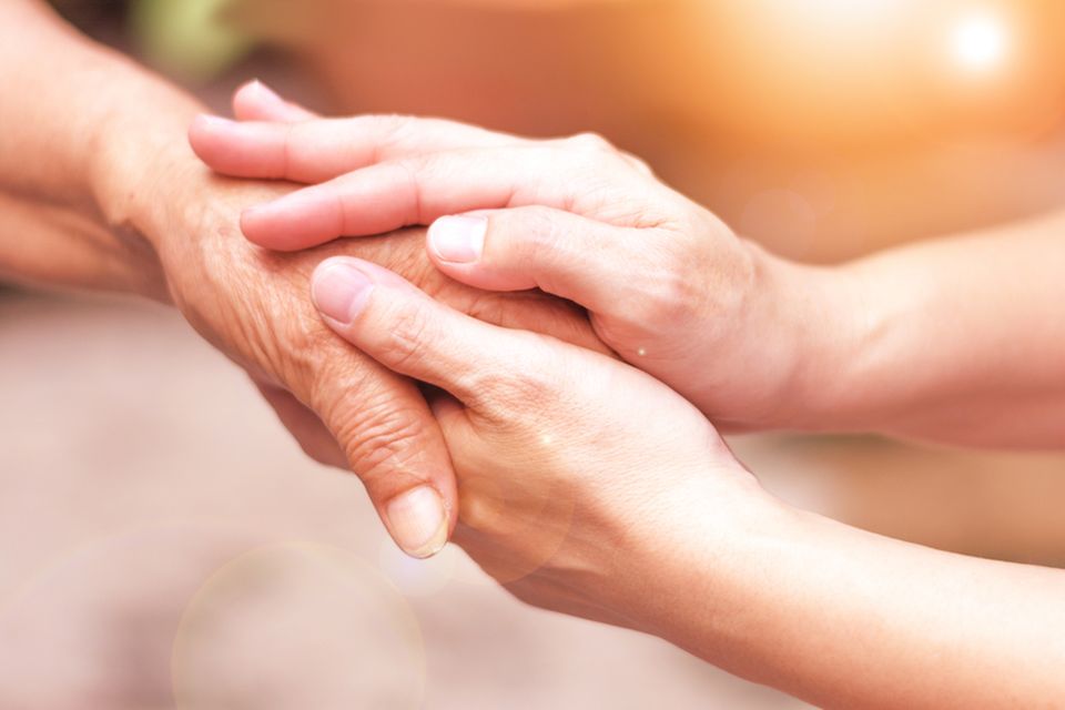 Hospiz Pflegerin und Seniorin halten Hände
