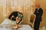 Hochzeitsfoto: Bräutigam küsst sitzende Braut