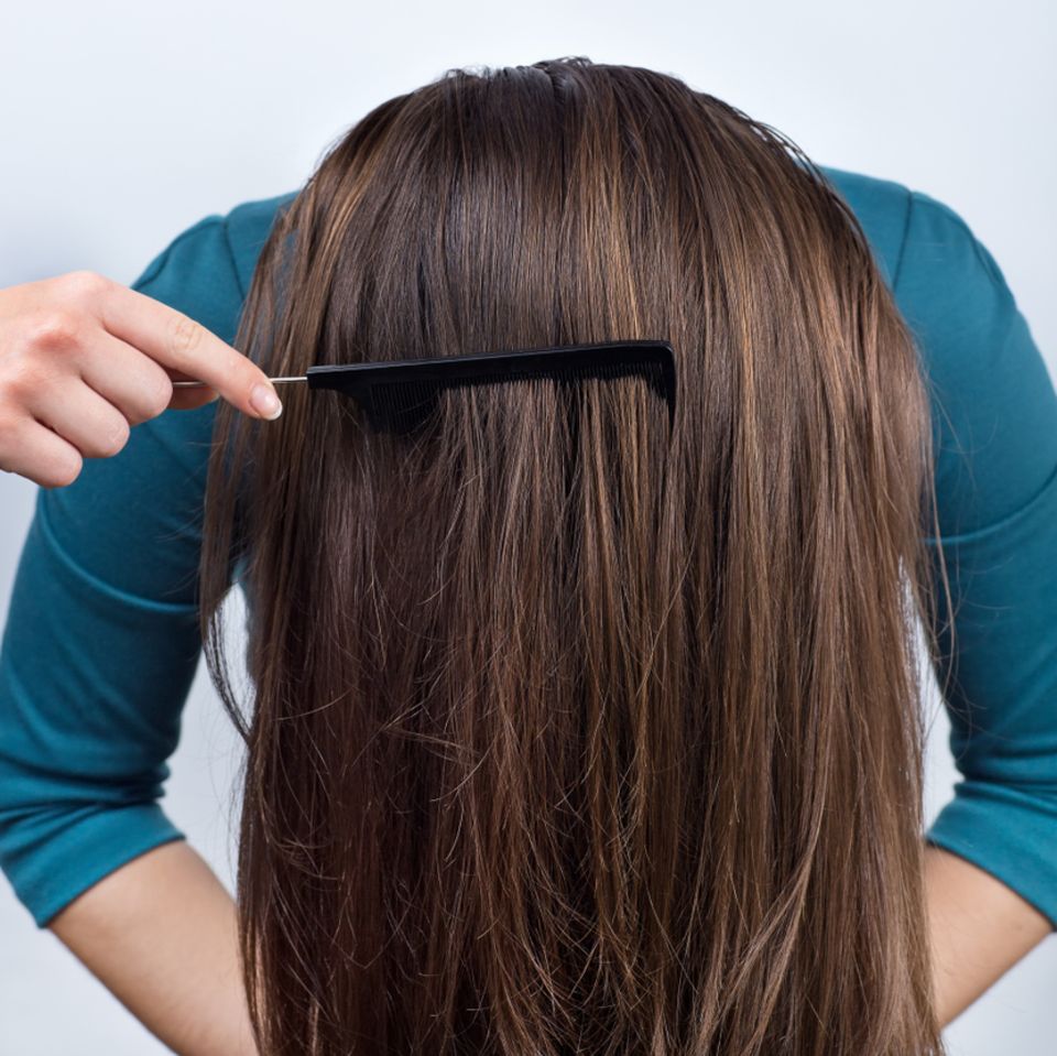 Einfache Frisuren: Frau beugt sich mit offenen Haaren nach vorne und wird gekämmt