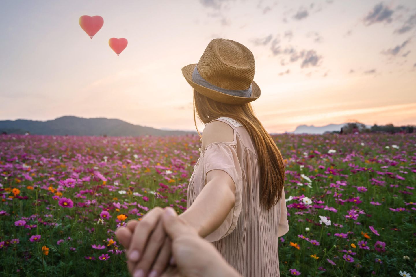 Horoskop: Eine Frau führt ihren Freund über eine Blumenwiese