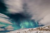Polarlichter: Schneebedeckter Berg, im Himmel grüne Polarlichter