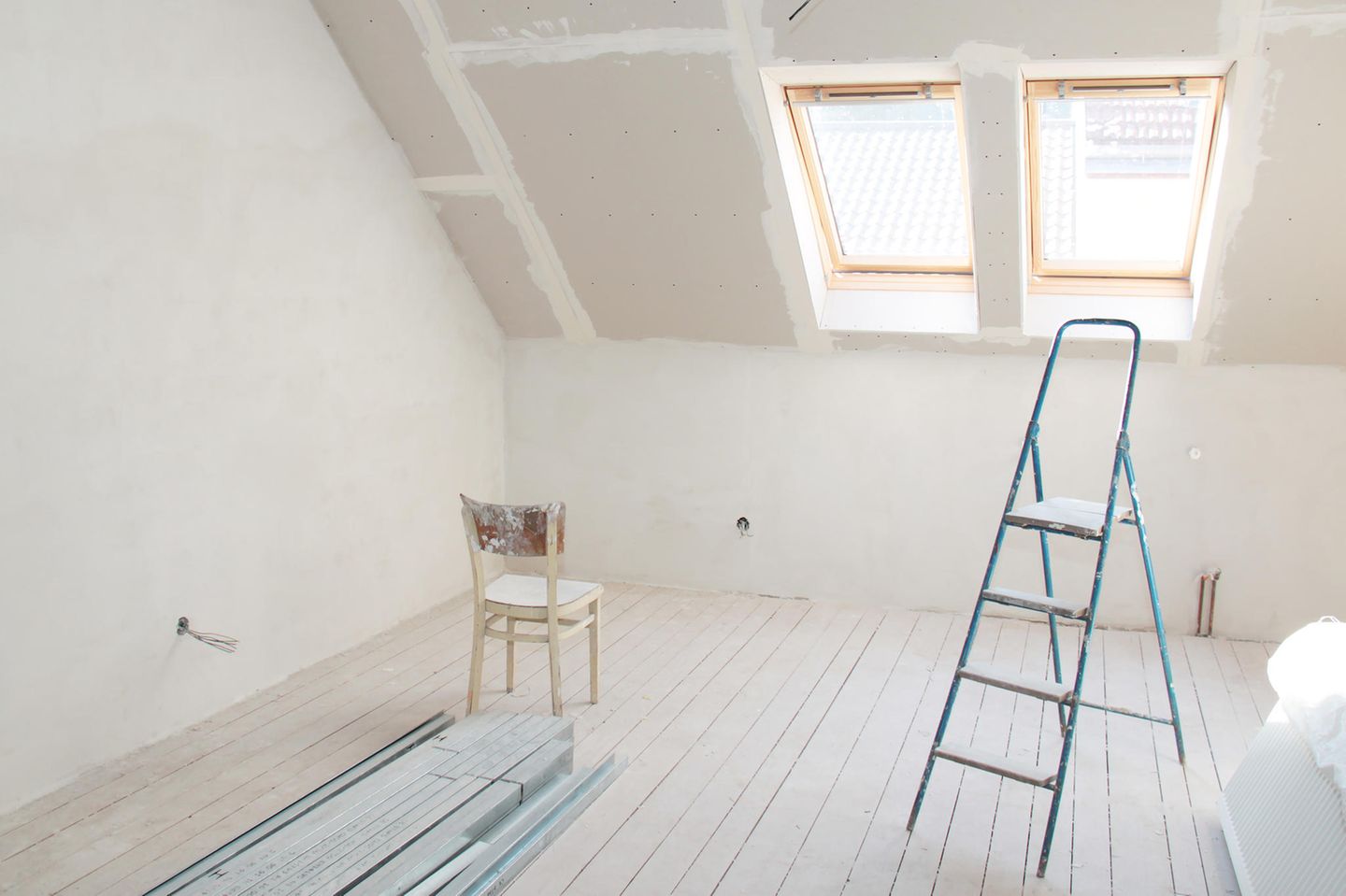 Dachboden ausbauen: Stuhl und Leiter im leeren Dachboden