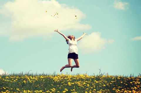 Horoskop: Eine Frau springt vor Freude in die Luft