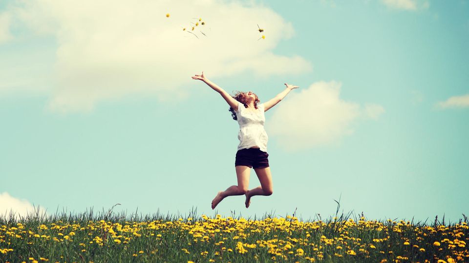 Horoskop: Eine Frau springt vor Freude in die Luft