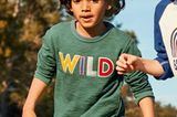 Kindermode: Junge in grünem Pullover