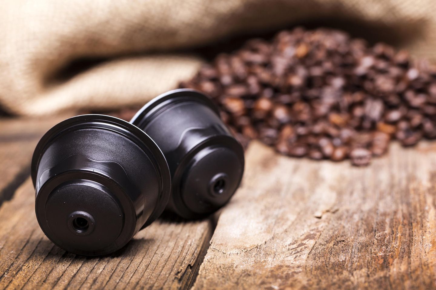 Rezemo Kaffeekapsel: Kaffeekapsel neben Kaffeebohnen