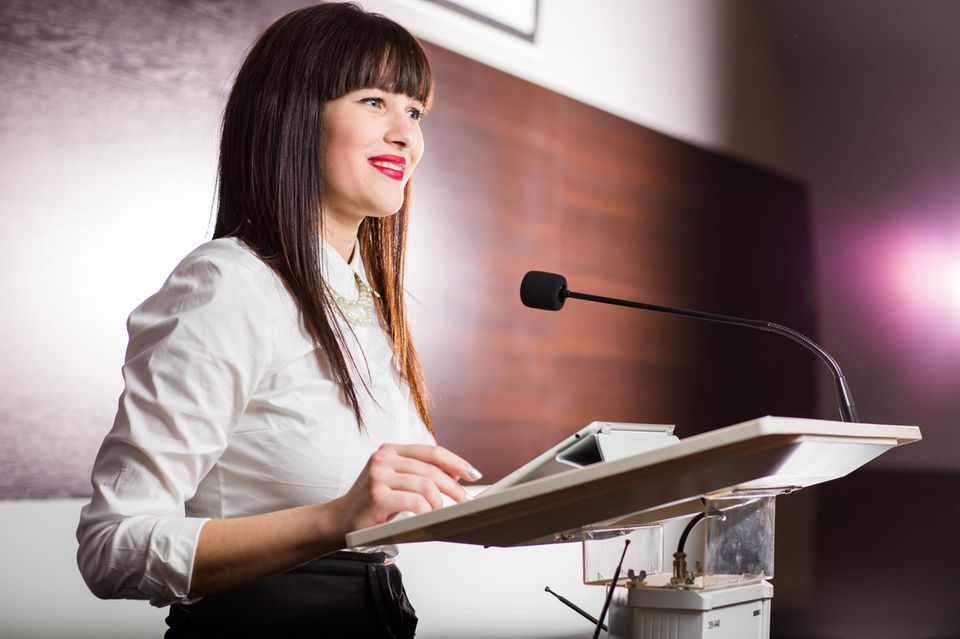Redeangst überwinden - vor Publikum sprechen lernen: Frau an Rednerpult