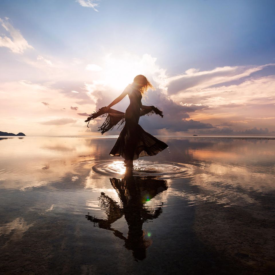 Wasserzeichen: Eine Frau tanzt im flachen Wasser