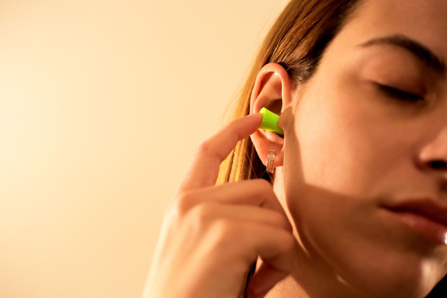 Tinnitus-Behandlung: Frau nutzt Ohrstöpsel