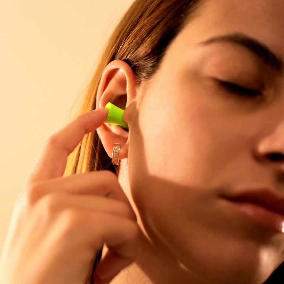 Tinnitus-Behandlung: Frau nutzt Ohrstöpsel