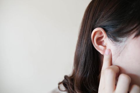 Hörsturz-Symptome: Frau fasst sich ans Ohr