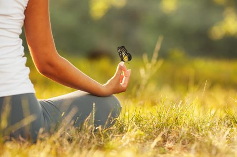 Studie: Eine Frau macht Yoga mit einem Schmetterling