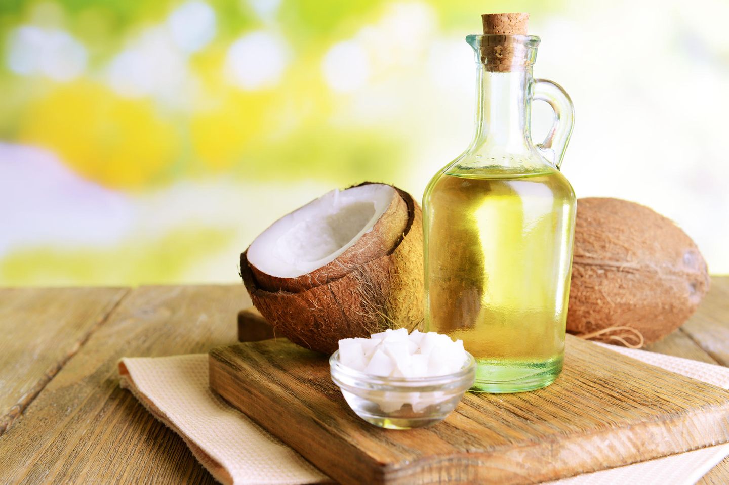 Mit Kokosöl abnehmen: Kokosöl und Kokosnuss auf Holztisch