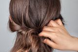 Frisuren selber machen: Haare werden um Haarband gewickelt