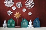 Bastelideen Weihnachten: Schneeflocken aus Papier und Holzhäuser