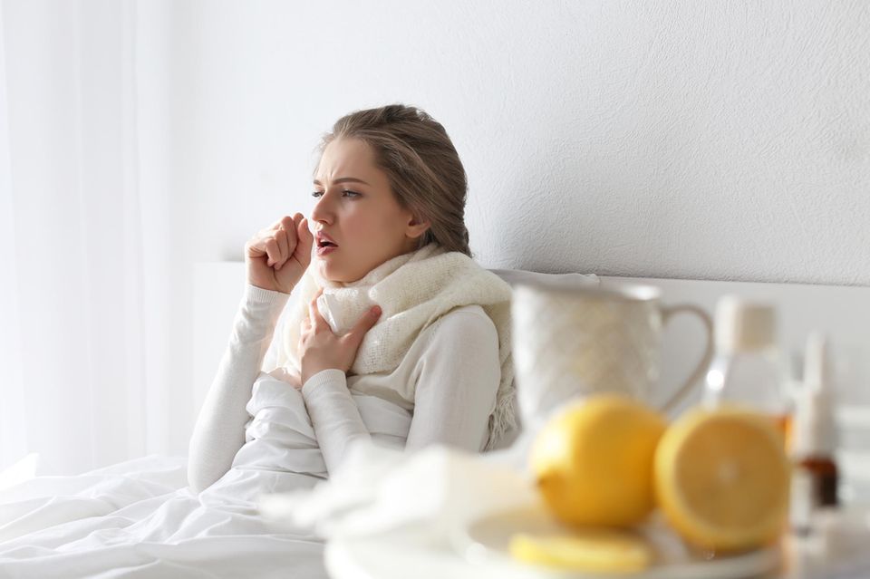 Ist Bronchitis ansteckend? Kranke Frau im Bett