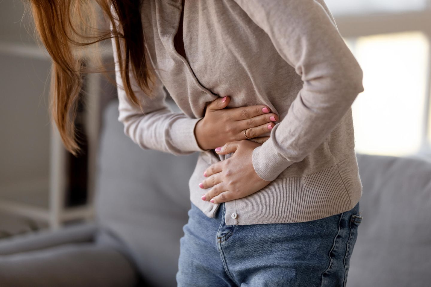 Hausmittel gegen Magen-Darm-Grippe: Frau hält sich den Magen