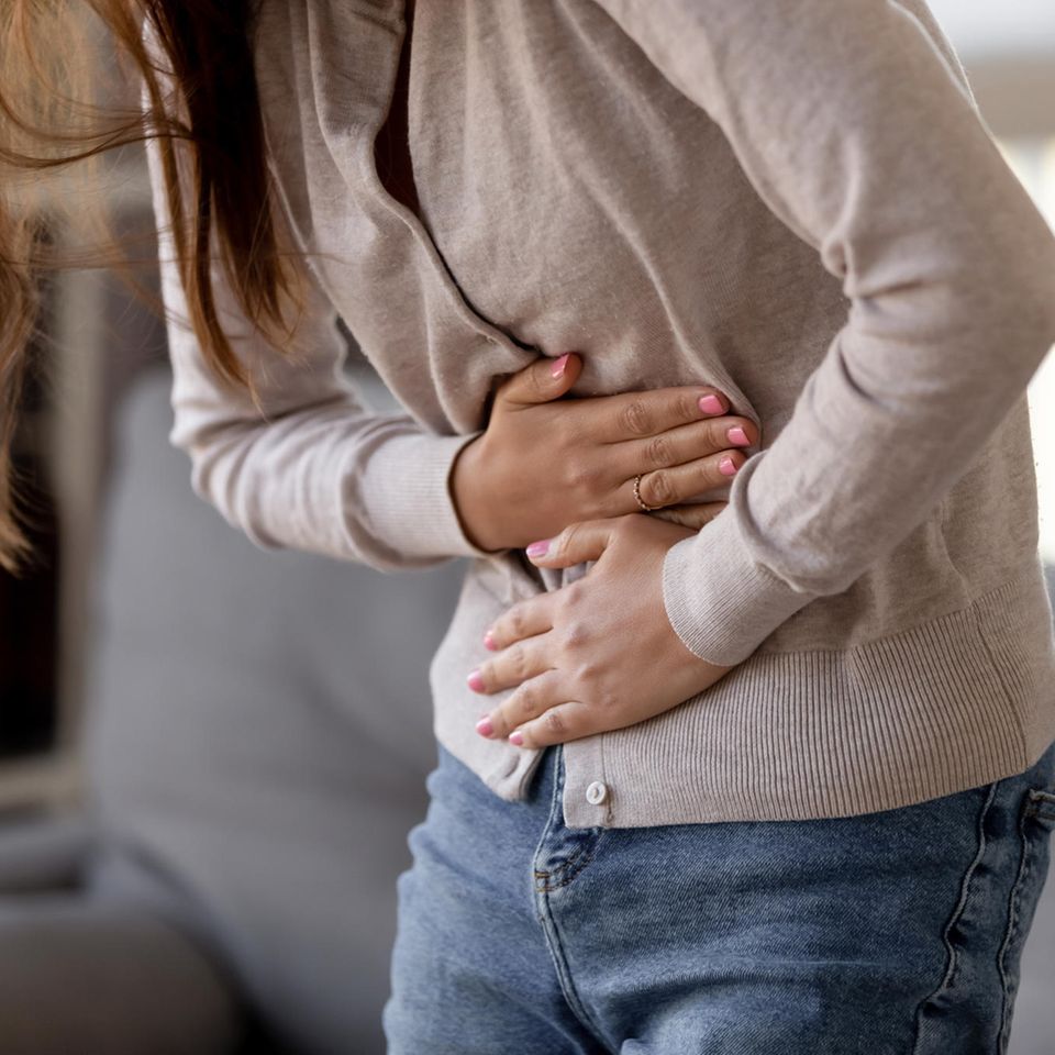 Hausmittel gegen Magen-Darm-Grippe: Frau hält sich den Magen