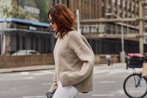 Pullover-Trends im Herbst: Frau mit Pullove rund weißer Hose