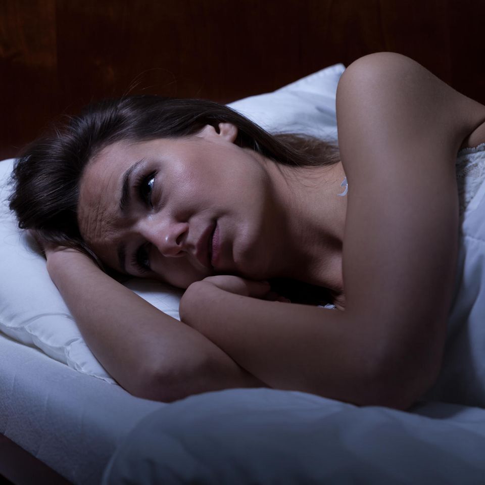 Gründe für Schlafprobleme: Frau liegt wach im Bett