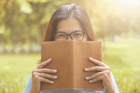 Buchhülle nähen : Frau hält sich offenes Buch vor das Gesicht