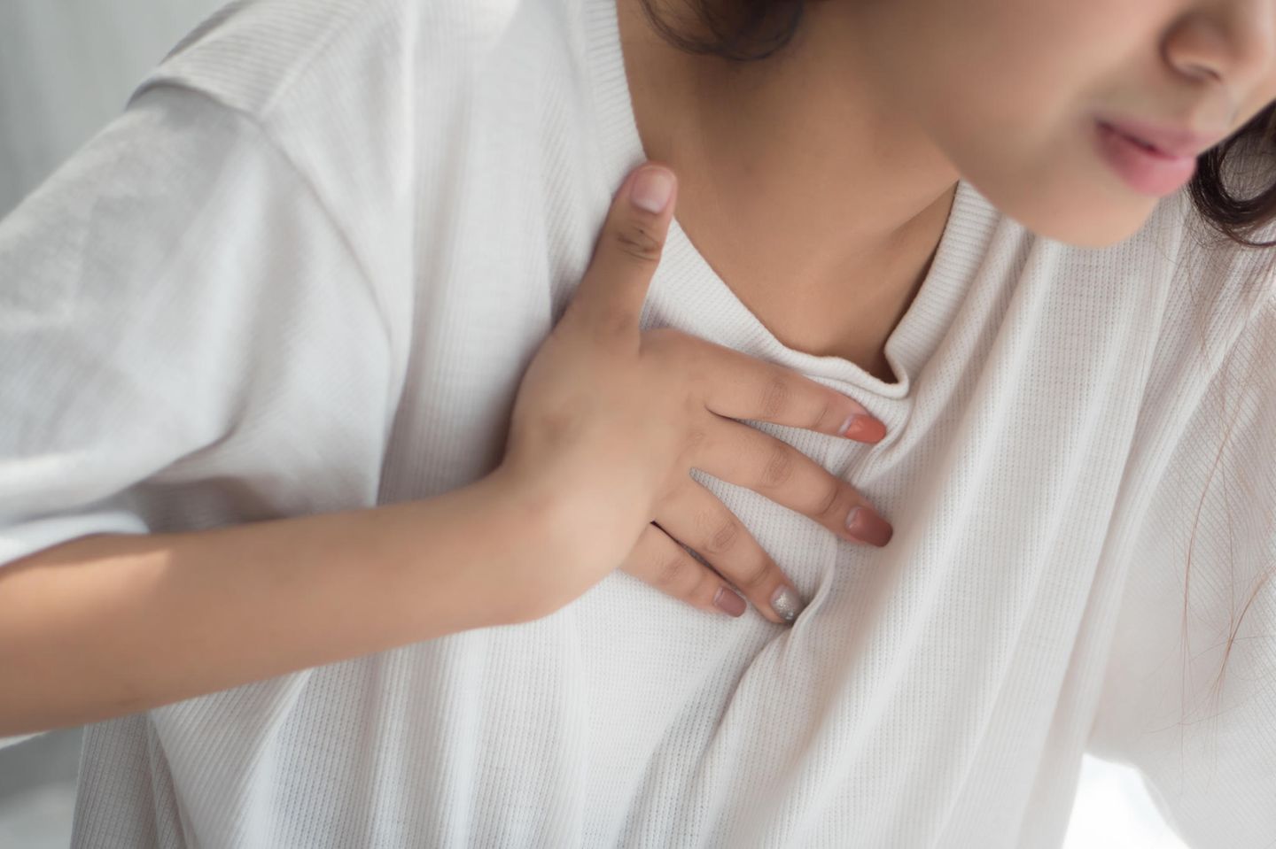 Reflux: Frau fasst sich an den Brustkorb
