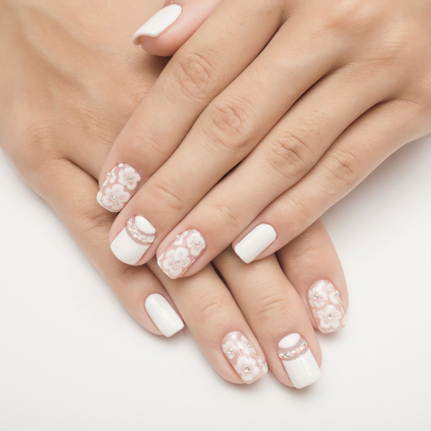 Hochzeitsnägel: Weiß lackierte Nägel mit Blumenmuster und Glitzersteinen