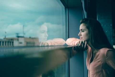 Selbstsabotage: So bekämpfst du deinen inneren Feind: Frau schaut nachdenklich aus dem Fenster