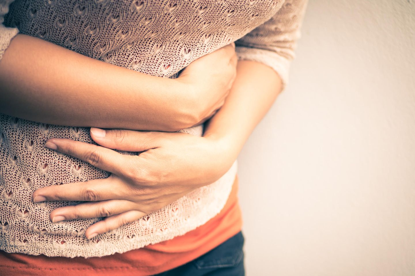 Flat stomach: woman holds her stomach