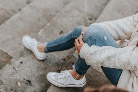 Igitt! Experten raten, unsere Jeans nicht zu waschen: Frau in Jeans auf Treppe sitzend