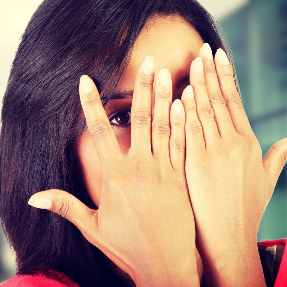 Anonymer Test: Frau bedeckt ihr Gesicht mit den Händen