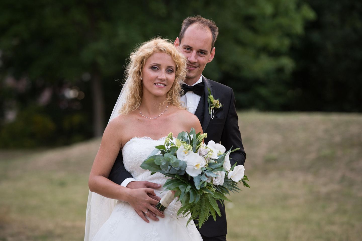 Hochzeit auf den ersten Blick: Bräutigam umarmt Braut von hinten
