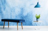 Wand streichen Ideen: Blaue Wand davor Sitzbank, Tisch und Lampe
